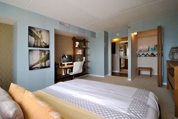 a bedroom with a bed and a desk in a hotel room